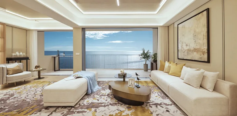 Coastal Cabana, artist&rsquo;s impression: a living room with sofas and a wide window looking out to the sea, in the developer&rsquo;s show-unit styling